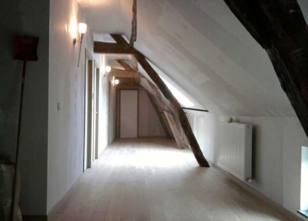 Inrichting zolder met houten deuren en balken